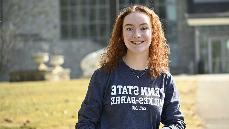 An image of a woman standing outside wearing a shirt that says "Penn State Wilkes-Barre Established 1916"
